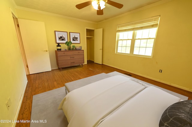 bedroom with light wood-type flooring, ceiling fan, and ornamental molding