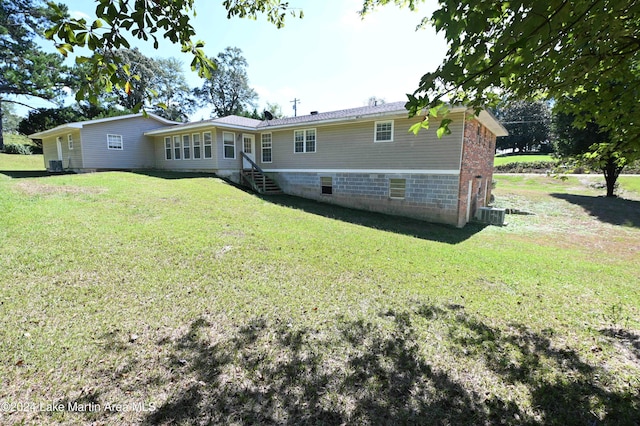 rear view of property with a yard