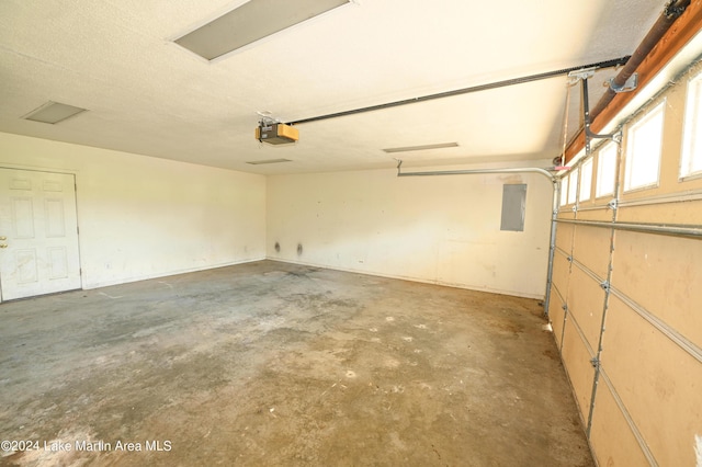 garage featuring electric panel and a garage door opener