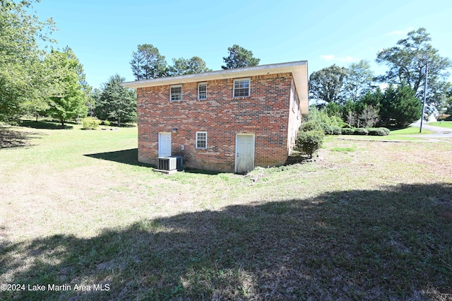 view of side of home featuring a yard and central air condition unit