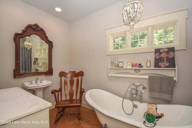 bathroom featuring a bathing tub, hardwood / wood-style floors, and an inviting chandelier