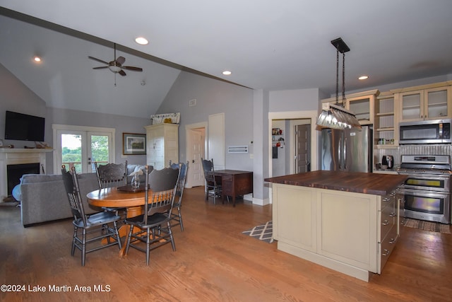 dining area featuring ceiling fan, light wood-type flooring, high vaulted ceiling, and french doors