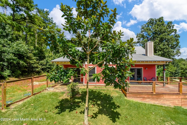 rear view of property with a lawn and a wooden deck