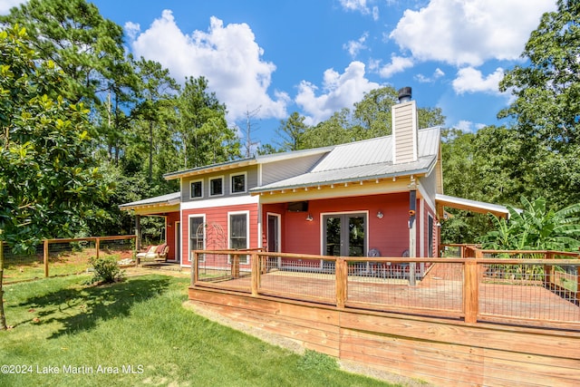 back of property featuring a deck and a yard