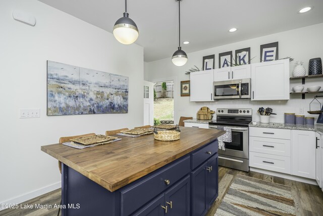 441 Cove Dr, Eclectic, AL 36024 - kitchen with butcher block countertops, white cabinets, appliances with stainless steel finishes, and blue cabinets