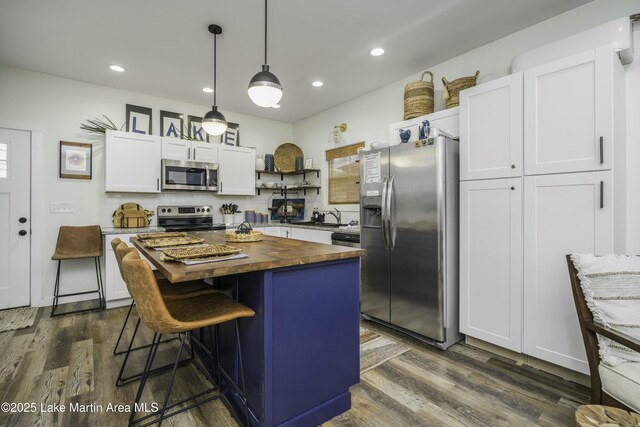 441 Cove Dr, Eclectic, AL 36024 - kitchen with open shelves, appliances with stainless steel finishes, dark wood finished floors, white cabinetry, and butcher block countertops