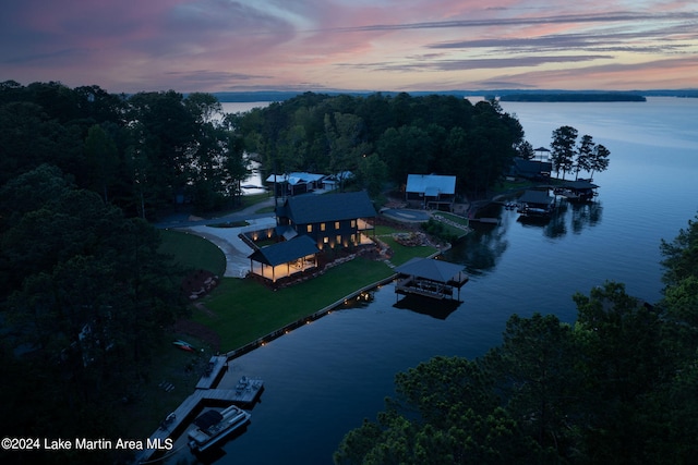 aerial view at dusk featuring a water view