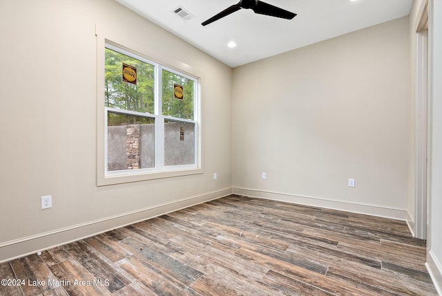 spare room featuring dark wood-type flooring and ceiling fan