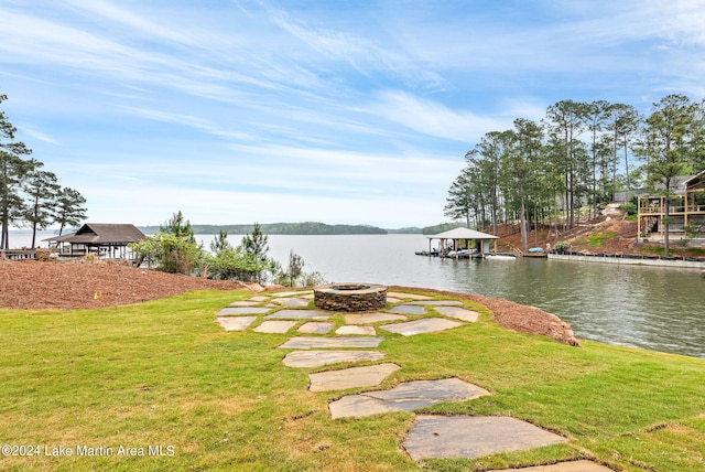 view of yard with an outdoor fire pit and a water view