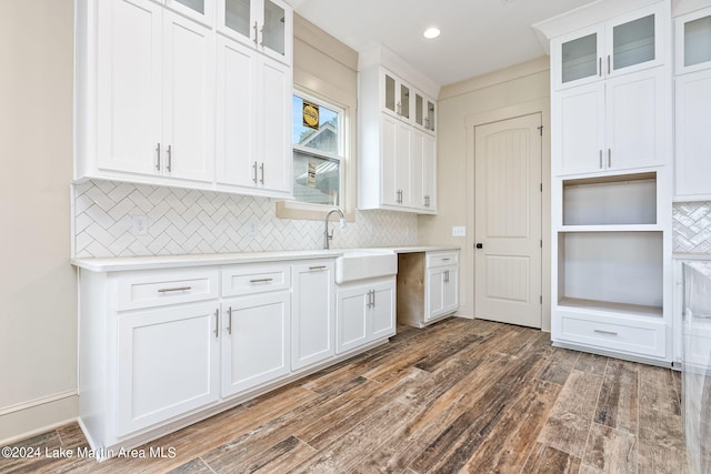 kitchen with sink, white cabinetry, backsplash, and dark hardwood / wood-style flooring