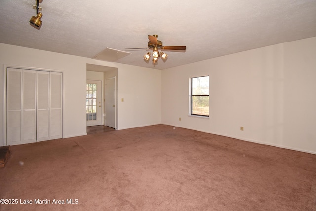 unfurnished room featuring ceiling fan, carpet floors, a textured ceiling, and a wealth of natural light