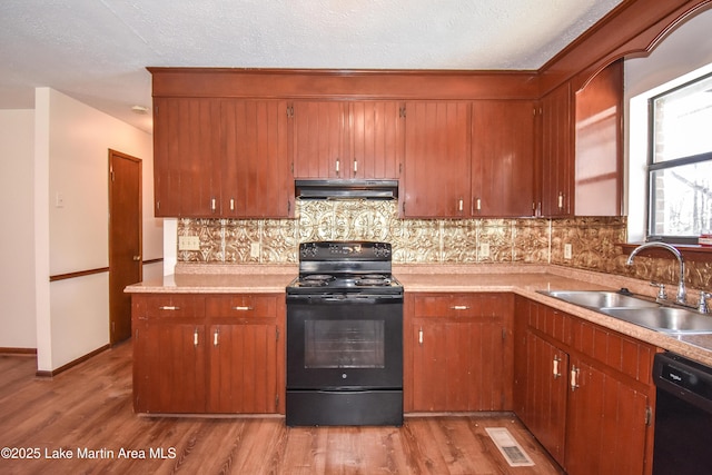 kitchen with black appliances, decorative backsplash, light wood-type flooring, and sink