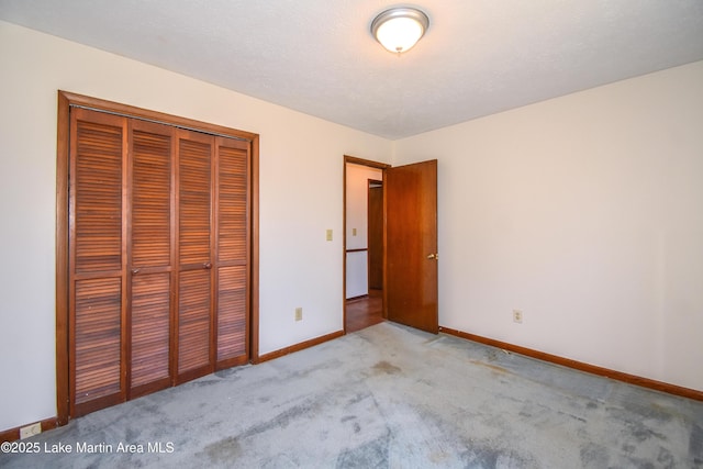 unfurnished bedroom with light colored carpet and a closet