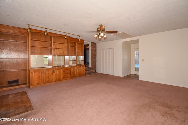 unfurnished living room with light carpet, a textured ceiling, rail lighting, and ceiling fan