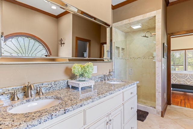 full bath with a stall shower, crown molding, and a sink