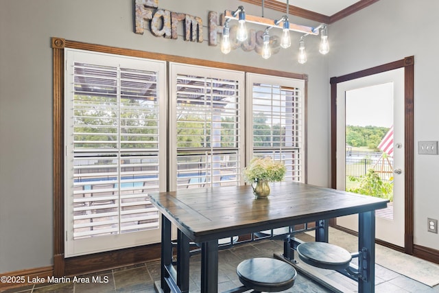 dining area with baseboards and crown molding