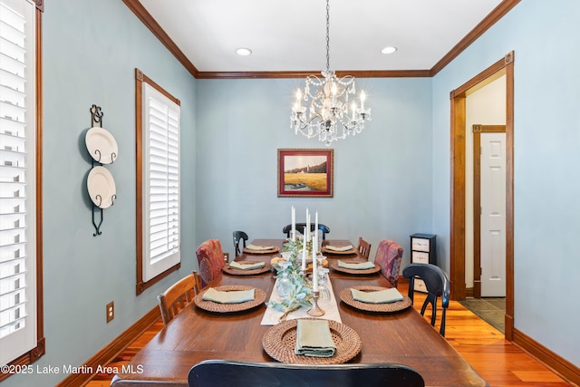 dining room featuring baseboards, ornamental molding, a chandelier, and wood finished floors