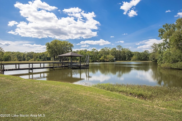 view of dock featuring a gazebo, a lawn, a water view, and a wooded view