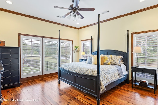 bedroom featuring ornamental molding, wood-type flooring, and visible vents