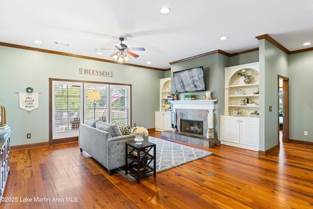 living room featuring a fireplace, baseboards, hardwood / wood-style floors, and recessed lighting