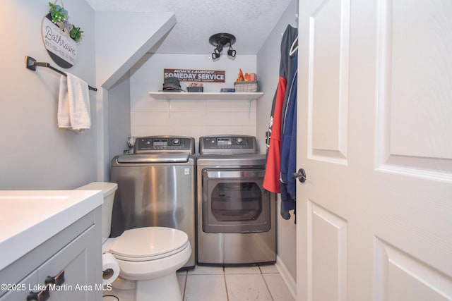 128 River Ridge Rd Unit B3, Alexander City, AL 35010 - laundry area featuring independent washer and dryer, light tile patterned flooring, and a textured ceiling