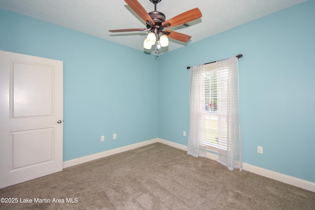 carpeted empty room with visible vents, baseboards, and ceiling fan