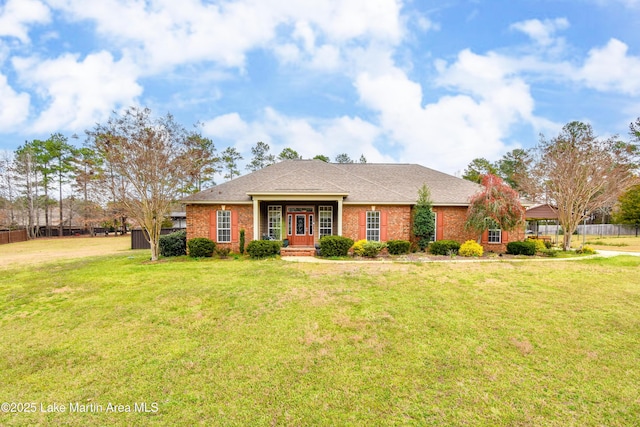 view of front of house featuring brick siding, a shingled roof, a front lawn, and fence