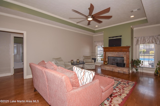 living area featuring a wealth of natural light, visible vents, and wood finished floors