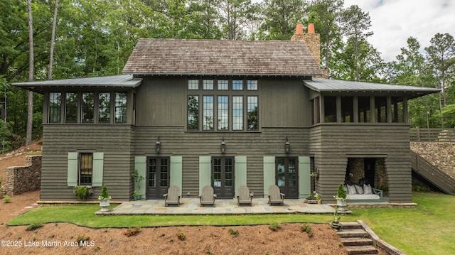 rear view of property with a patio, a sunroom, and a lawn