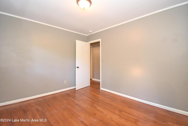 spare room featuring hardwood / wood-style floors and crown molding