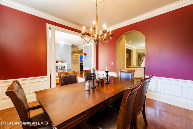 dining space featuring hardwood / wood-style floors, ornamental molding, and a notable chandelier