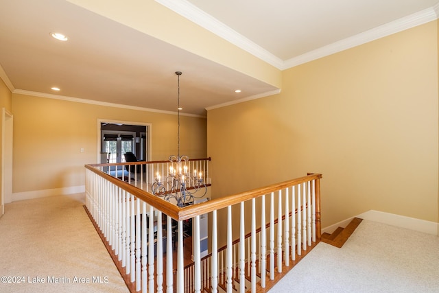 hallway with carpet flooring, crown molding, and a chandelier