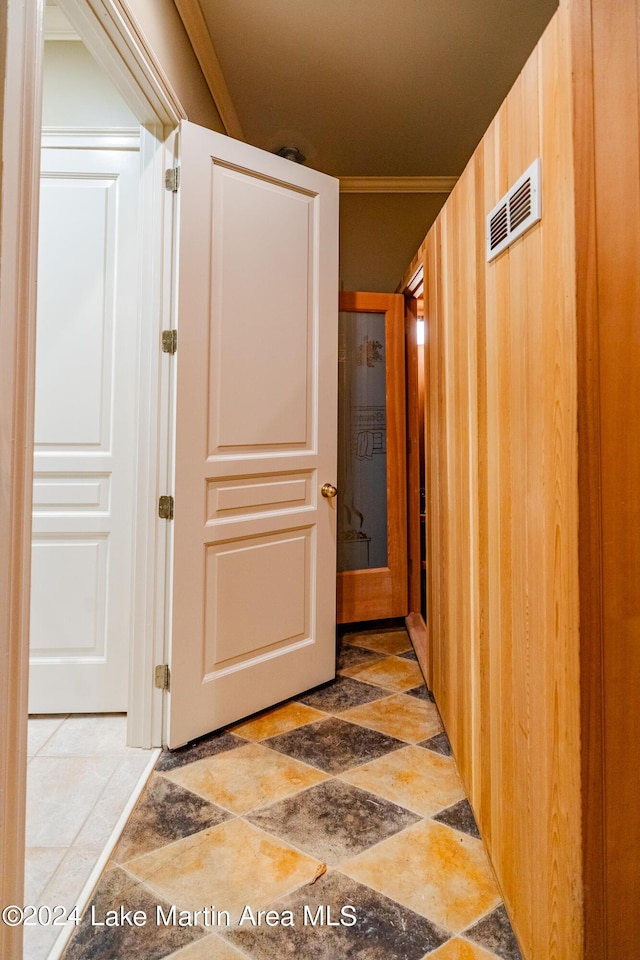 hall featuring crown molding and wood walls