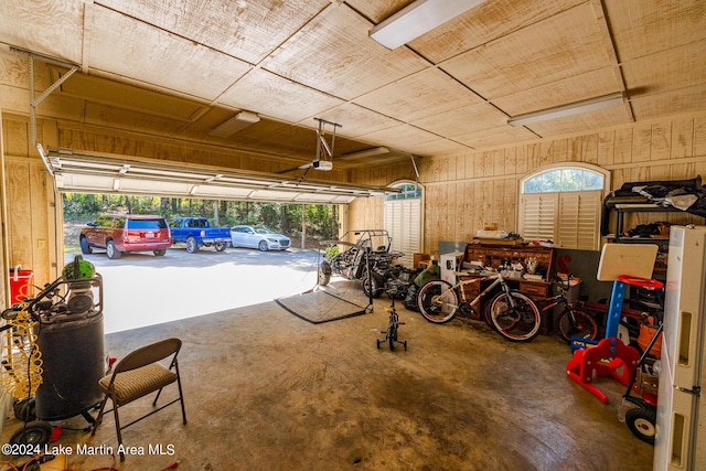 garage featuring wood walls and a garage door opener