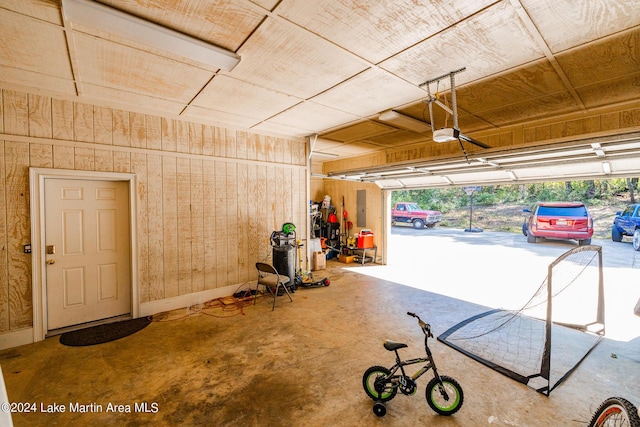 garage with wood walls and a garage door opener