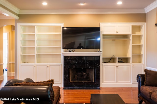 living room featuring hardwood / wood-style flooring, crown molding, and a premium fireplace