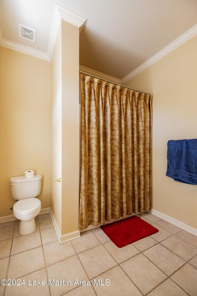 bathroom featuring tile patterned flooring, toilet, and ornamental molding