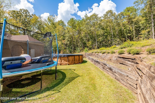 view of yard with a swimming pool and a trampoline