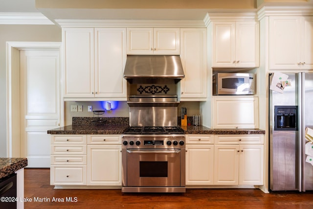 kitchen with stainless steel appliances, white cabinetry, dark hardwood / wood-style floors, and wall chimney range hood