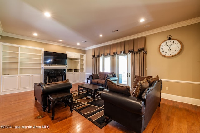 living room featuring hardwood / wood-style floors, a premium fireplace, and crown molding