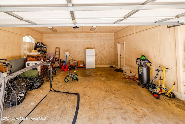 garage with white fridge and a garage door opener