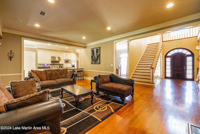 living room with wood-type flooring and ornamental molding