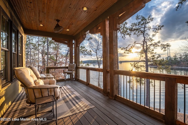 deck at dusk with ceiling fan and a water view