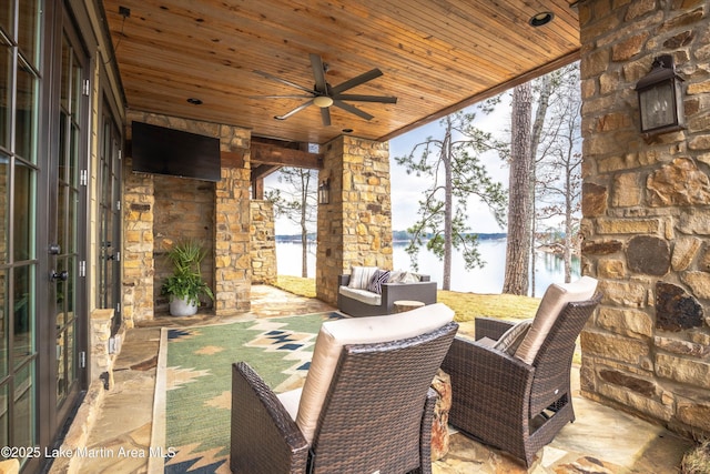 view of patio featuring an outdoor living space with a fireplace, ceiling fan, and french doors