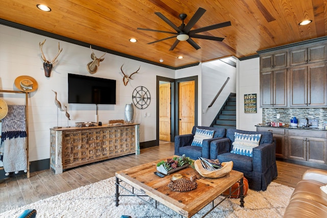 living room with ceiling fan, light wood-type flooring, and wood ceiling