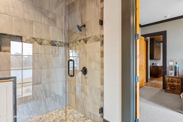 bathroom featuring ornamental molding and an enclosed shower