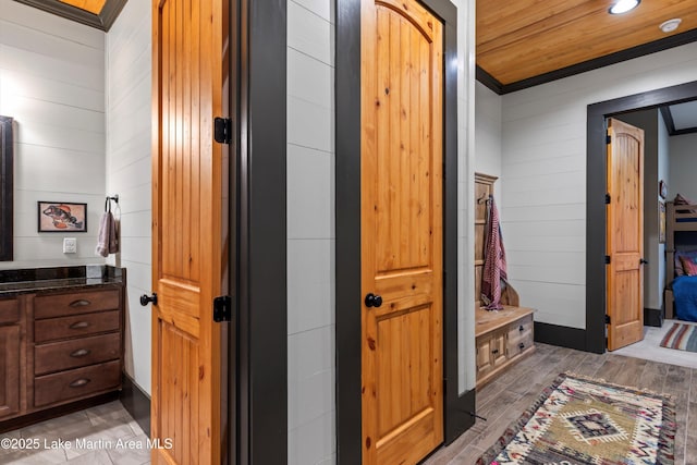 bathroom with wood walls, wood ceiling, ornamental molding, vanity, and hardwood / wood-style floors