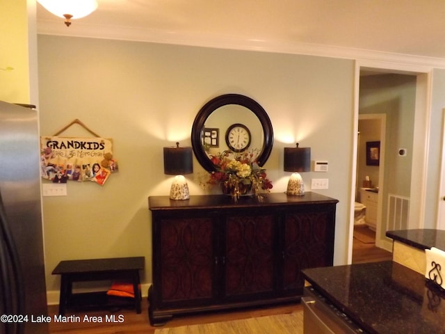 room details featuring hardwood / wood-style flooring, stainless steel fridge, and ornamental molding