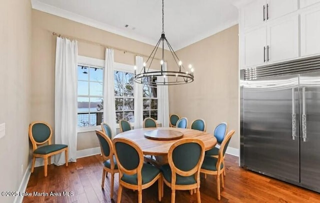 dining space with crown molding, dark wood-type flooring, and a chandelier