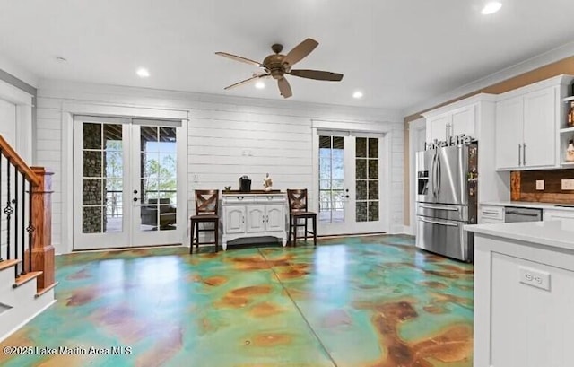 kitchen featuring ceiling fan, white cabinetry, concrete flooring, stainless steel appliances, and french doors